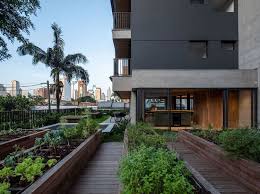 Modern apartment common area with wooden walkway and landscaped gardens